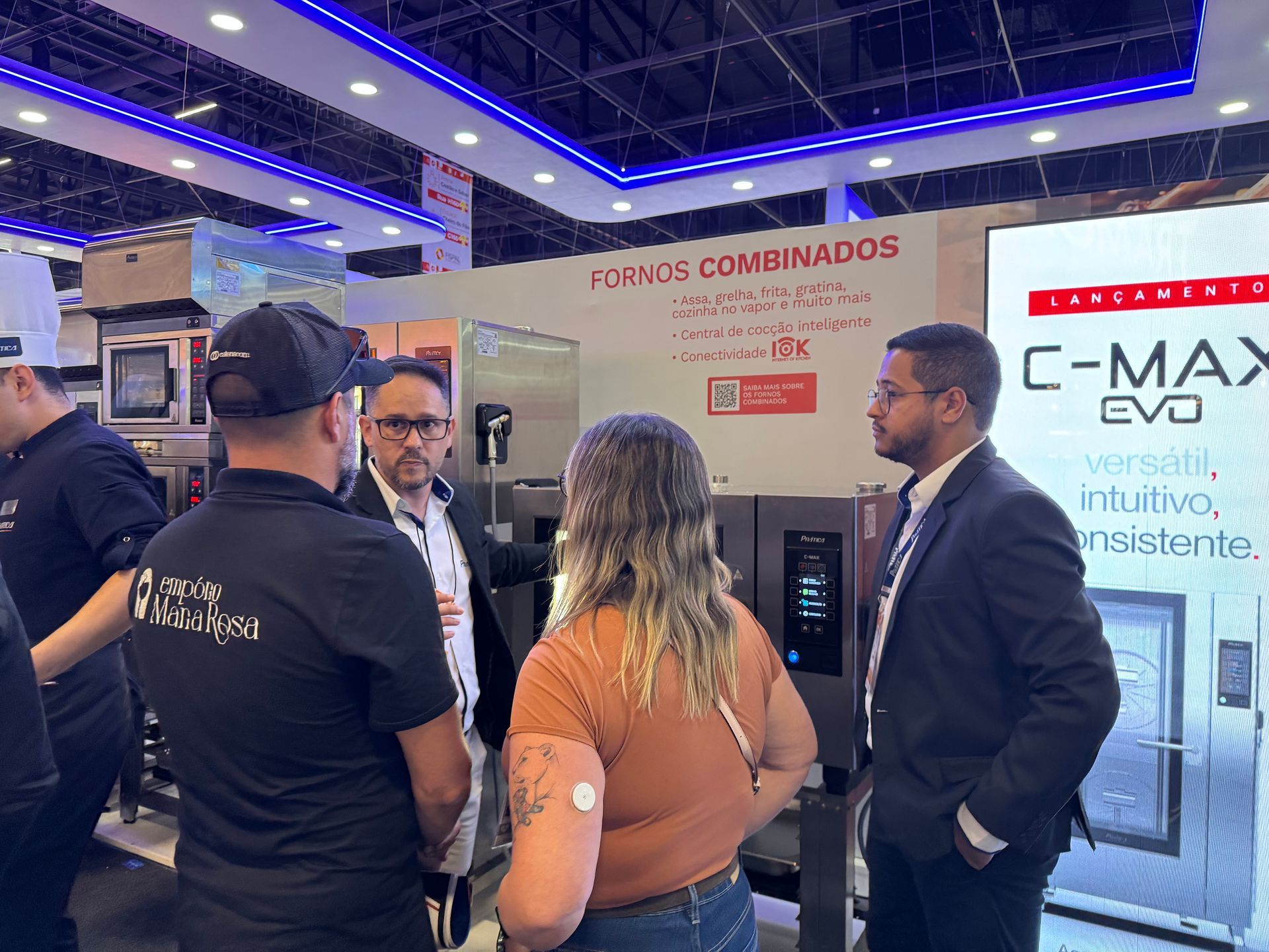 Um grupo de pessoas está em uma sala conversando entre si.