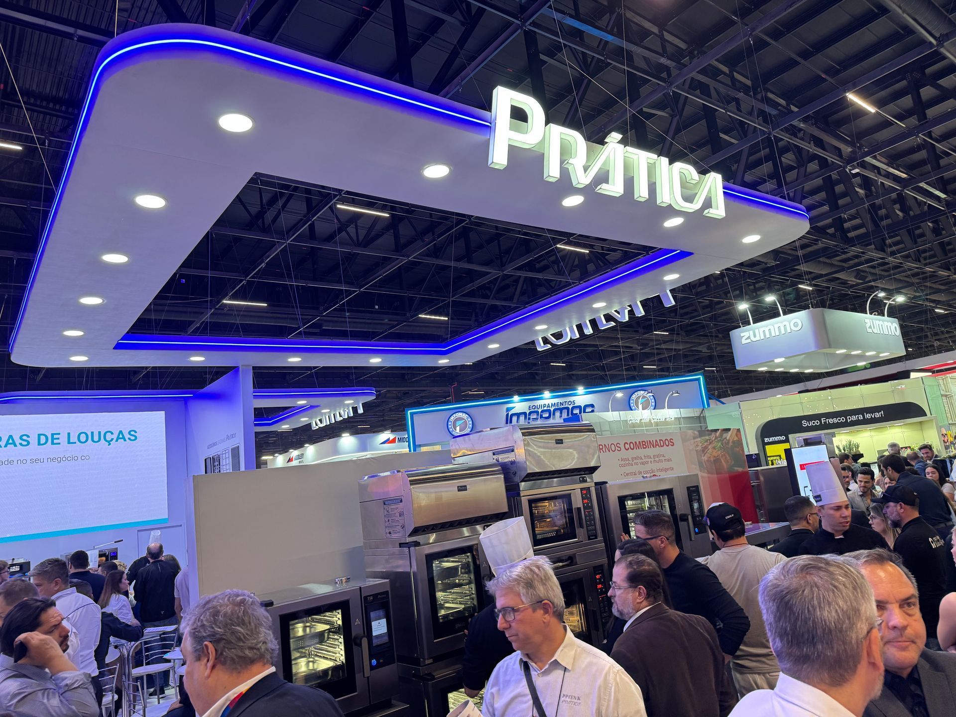 Um grupo de pessoas está reunido sob uma placa que diz primos