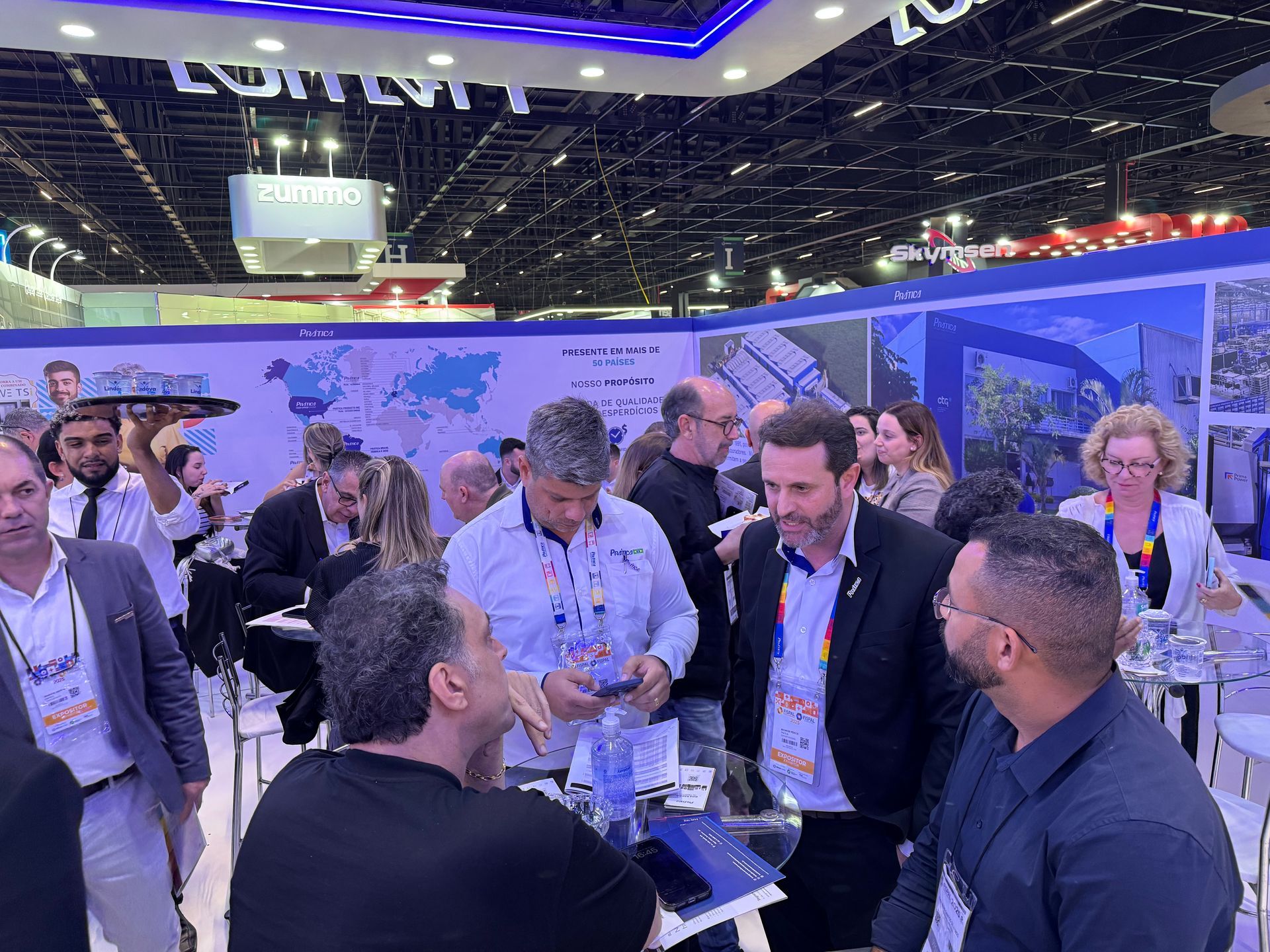 Um grupo de pessoas está em volta de uma mesa em uma convenção.