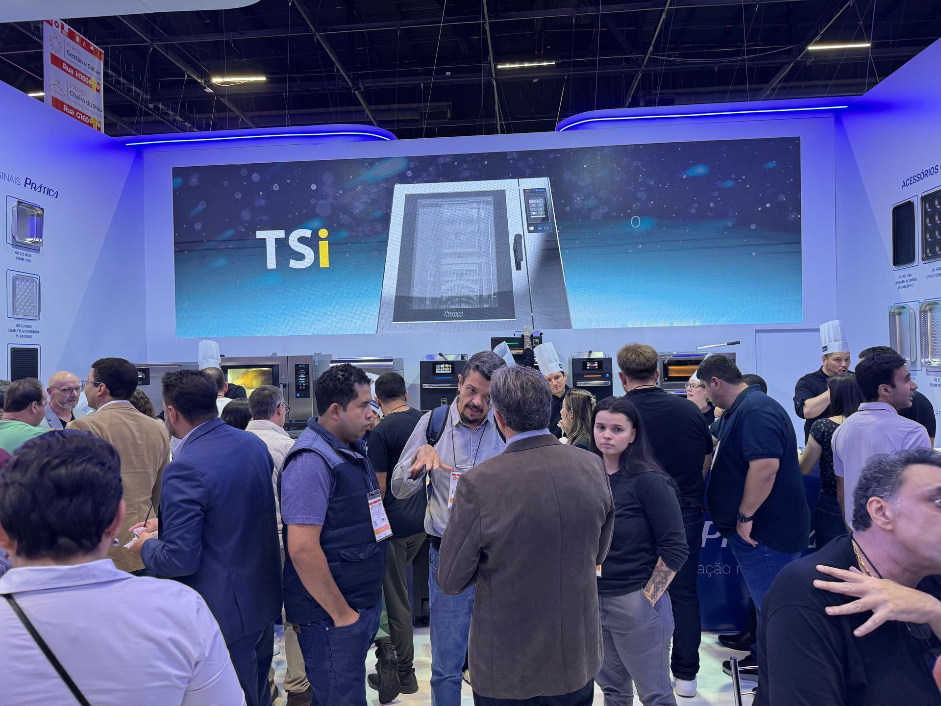 Um grupo de pessoas está em frente a uma placa que diz tsi.