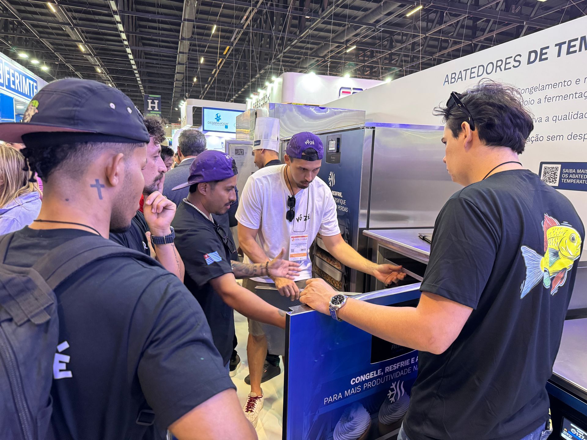 Um grupo de homens está em volta de uma máquina em uma convenção.