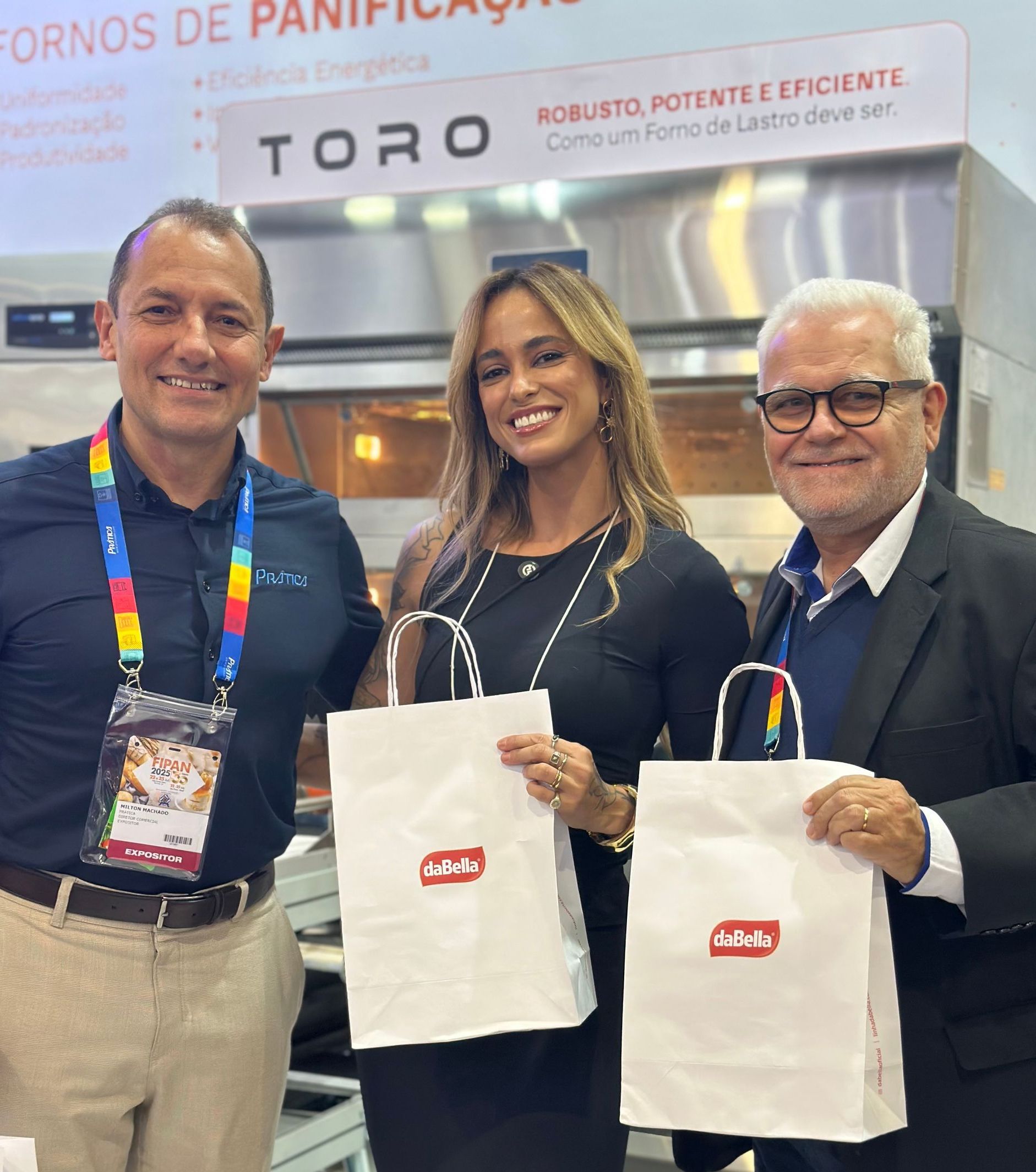 Três pessoas em pé uma ao lado da outra segurando sacolas com a palavra toro escrita nelas