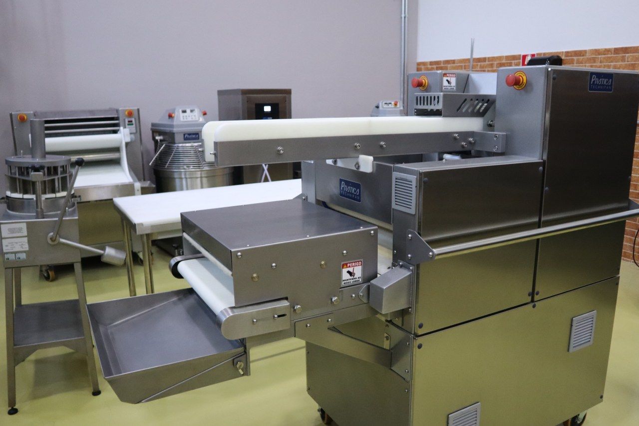 Uma máquina de aço inoxidável está em um carrinho em uma sala.