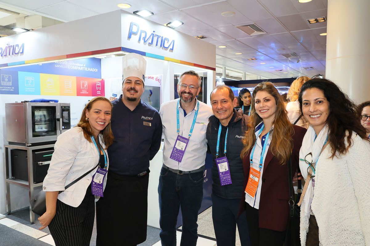 Pessoas em um estande de feira comercial com um forno Primos em exposição.