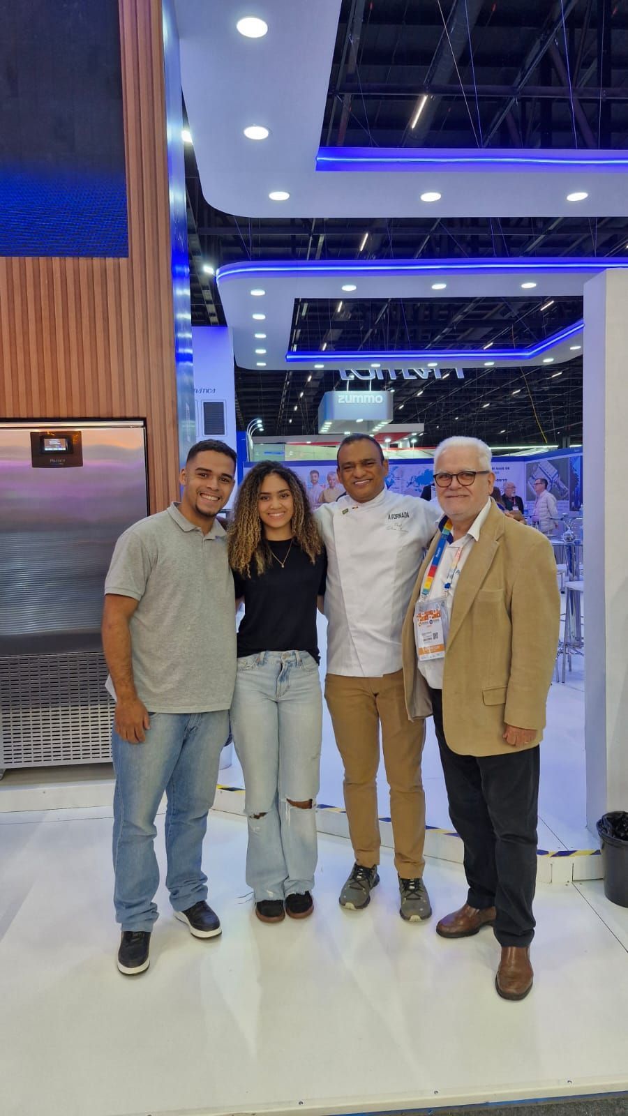 Um grupo de pessoas está posando para uma foto em uma sala.