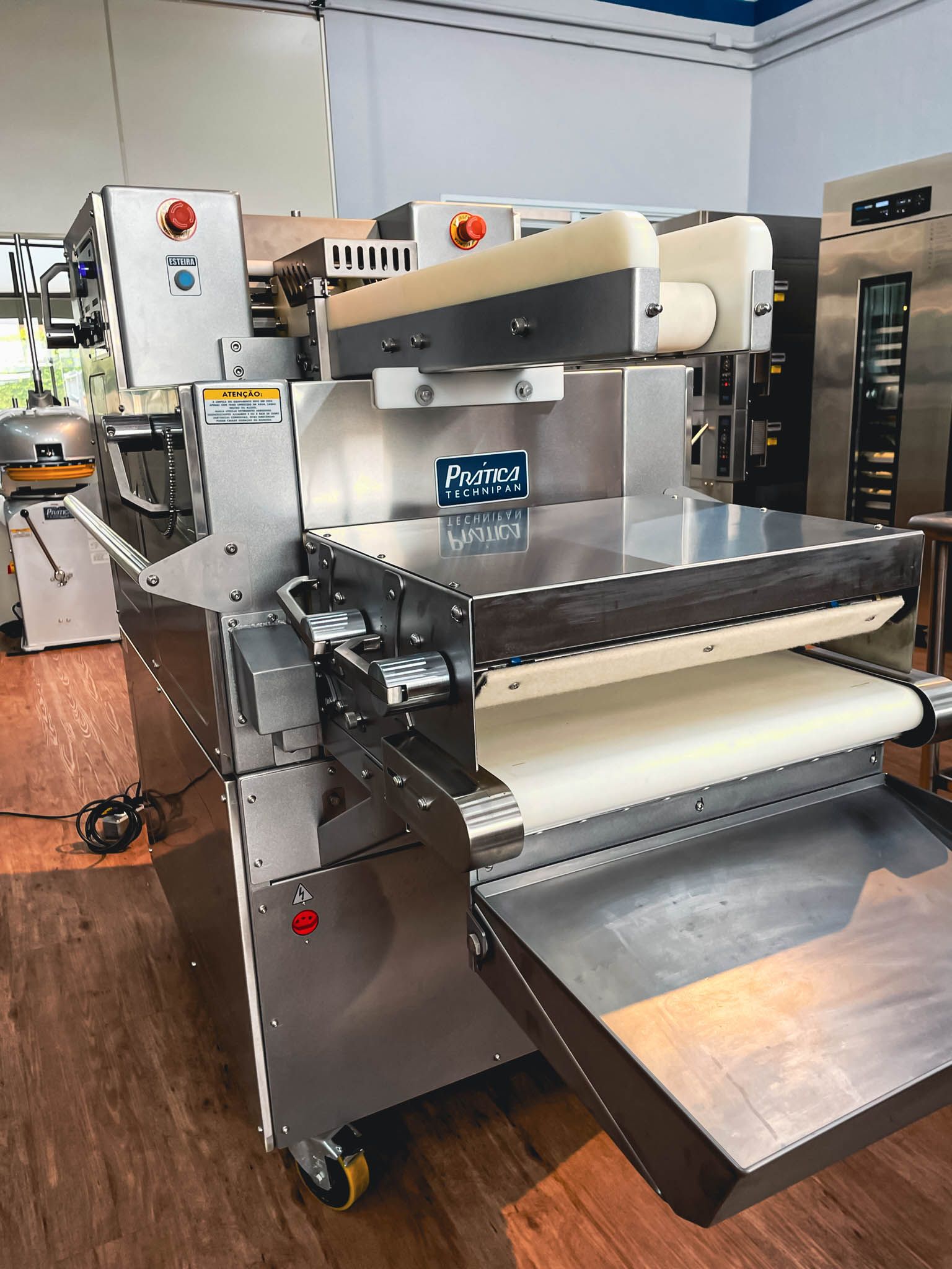 Uma máquina está sobre um piso de madeira em uma sala.
