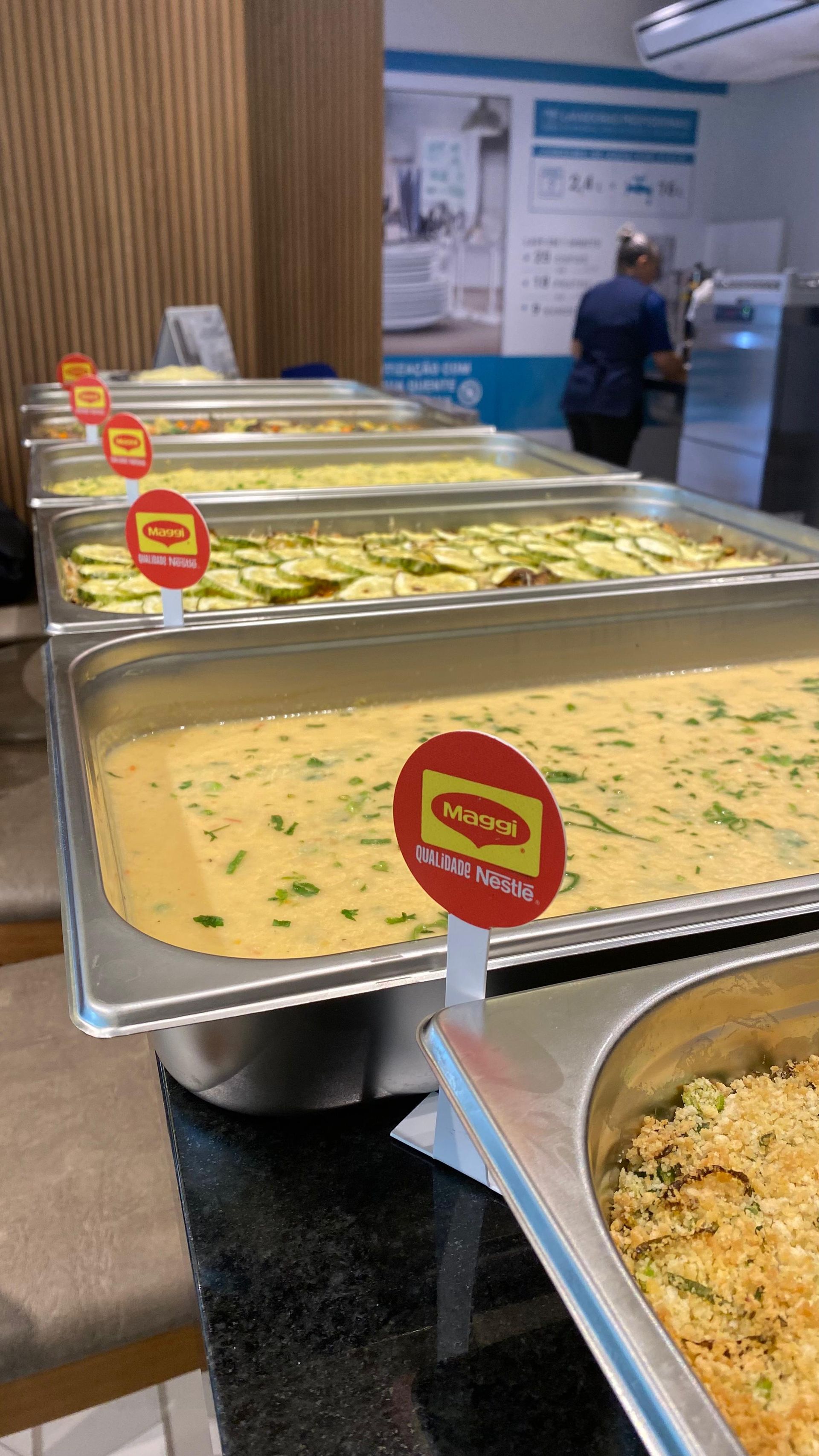 Há muitas bandejas de comida na mesa de um restaurante.