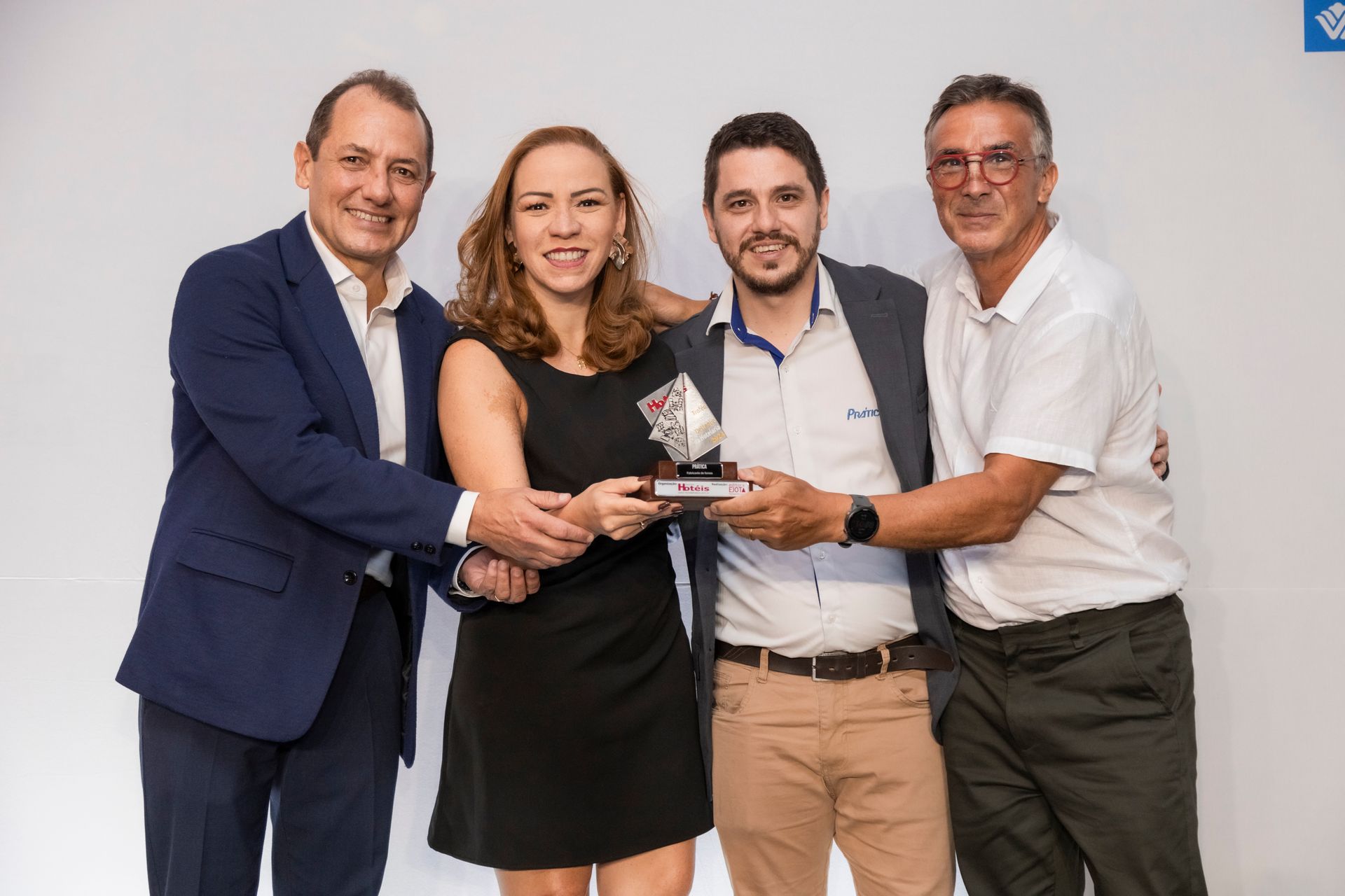 Um grupo de pessoas de pé, uma ao lado da outra, segurando um troféu.