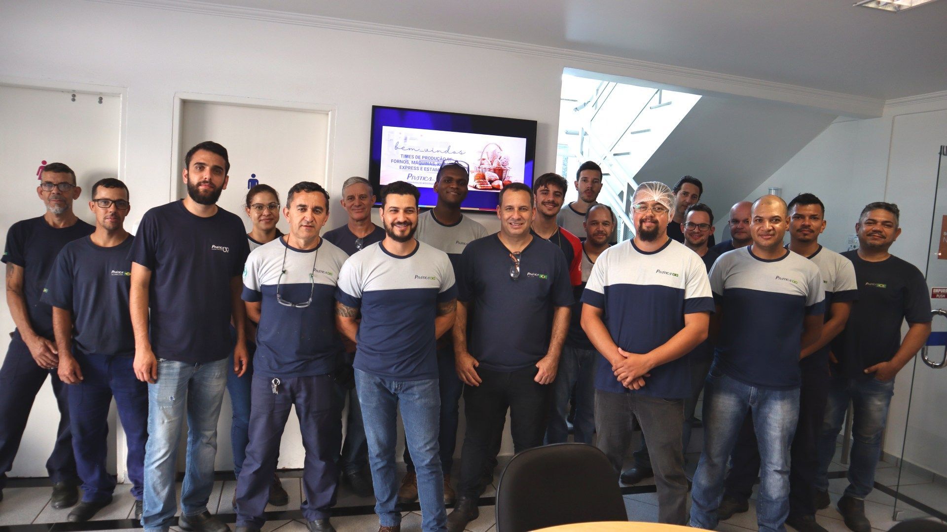Um grupo de homens está posando para uma foto em uma sala.