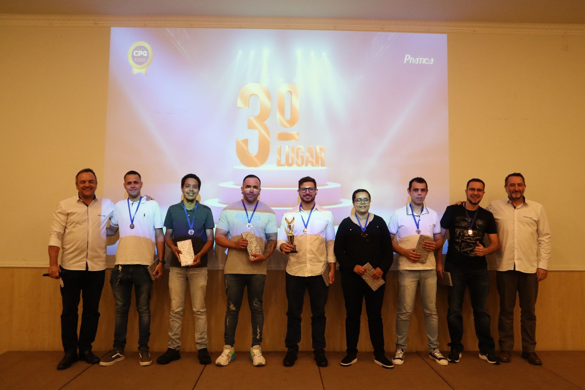 Um grupo de homens está em pé em frente a uma tela de projetor.