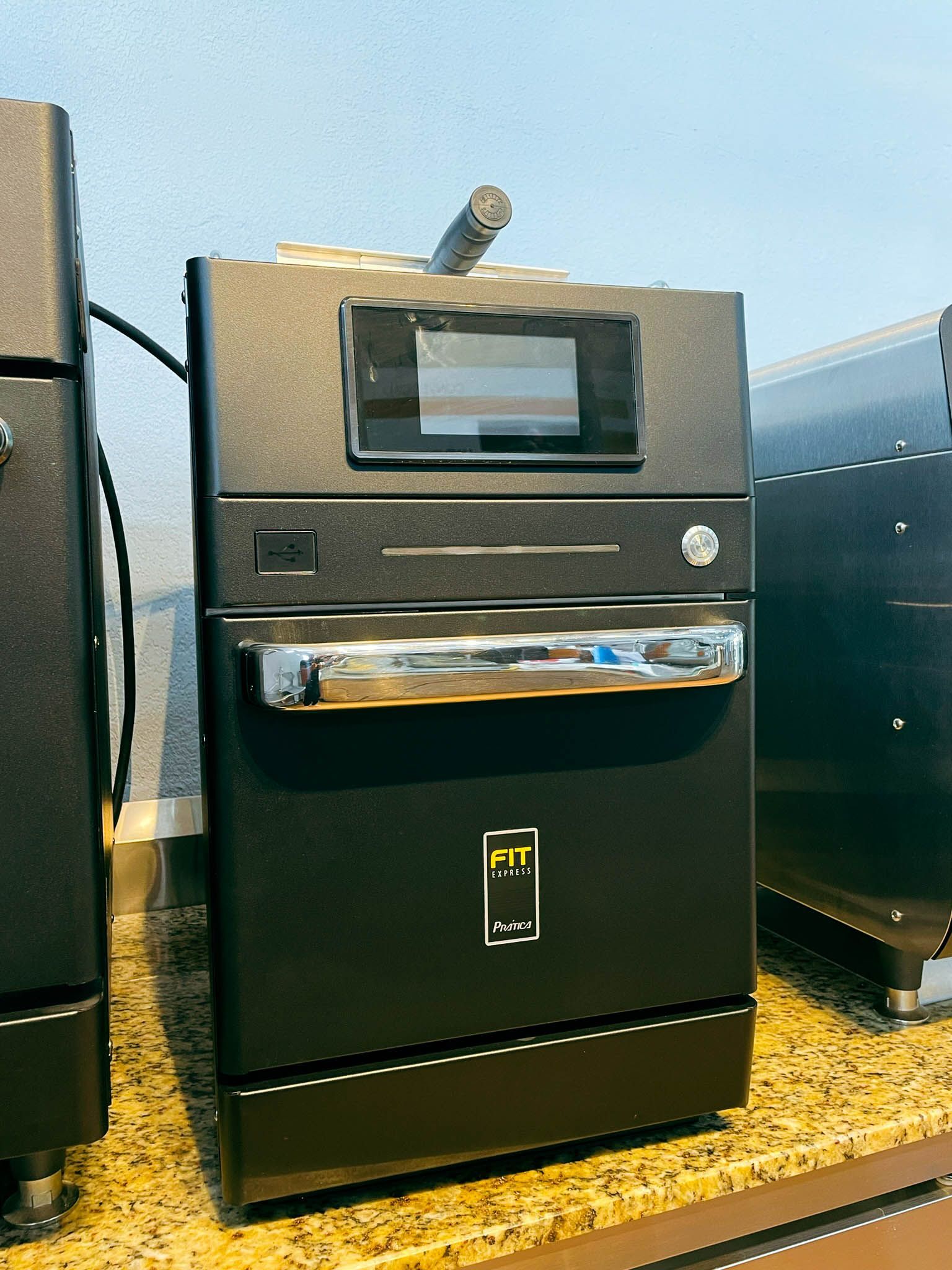 Um forno preto está sobre uma bancada de granito.