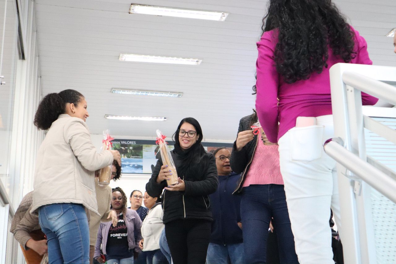 Um grupo de mulheres está de pé em um corredor segurando flores.
