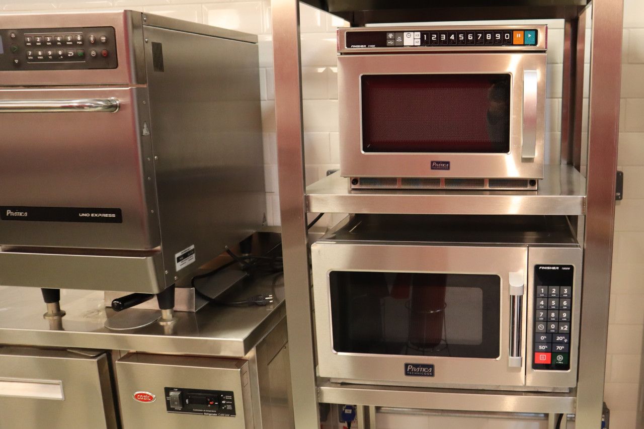 Três fornos de micro-ondas empilhados um em cima do outro em uma cozinha