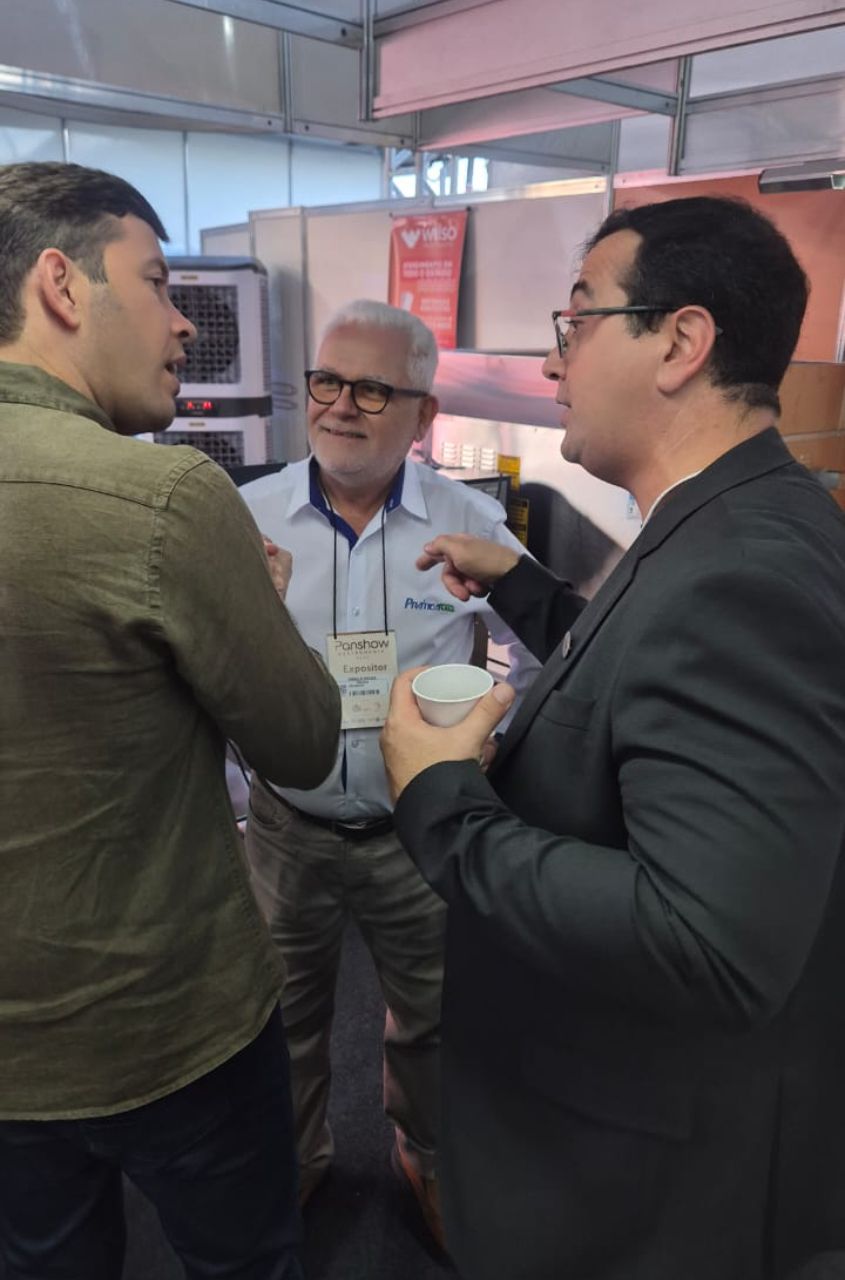 Um grupo de homens estão em uma sala conversando entre si