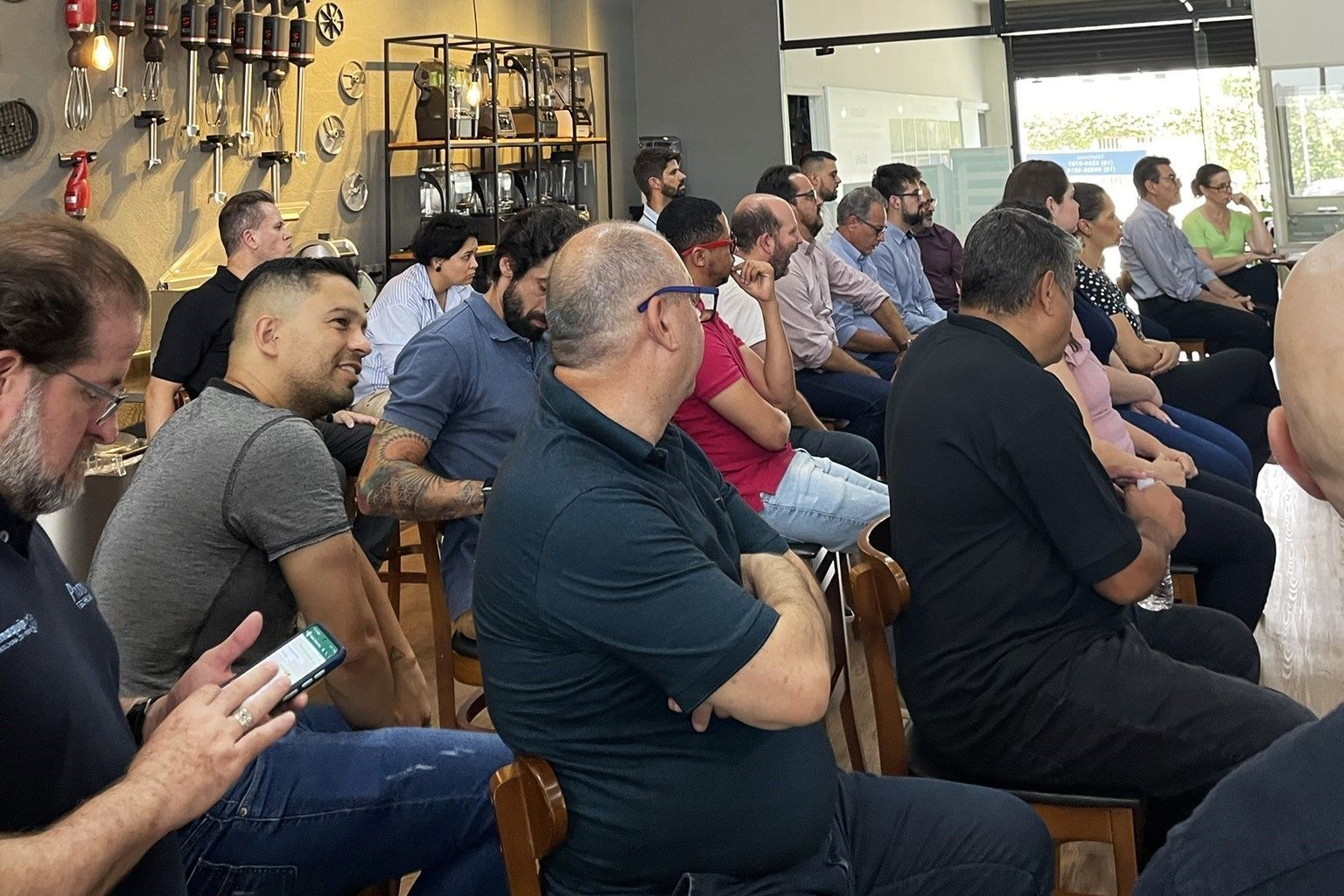 Um grupo de pessoas está sentado em cadeiras em uma sala.