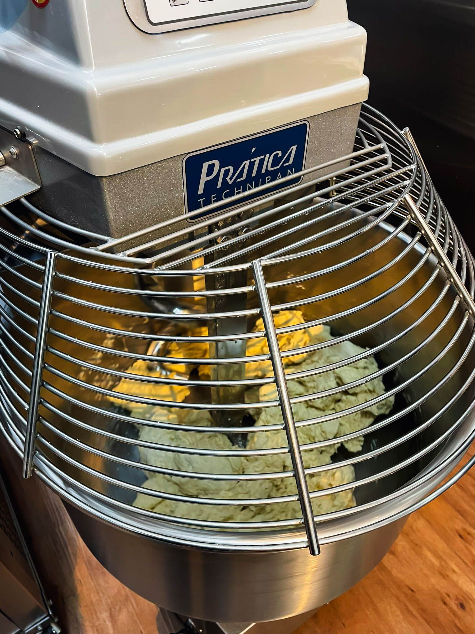 Uma batedeira com uma gaiola de arame é preenchida com massa.