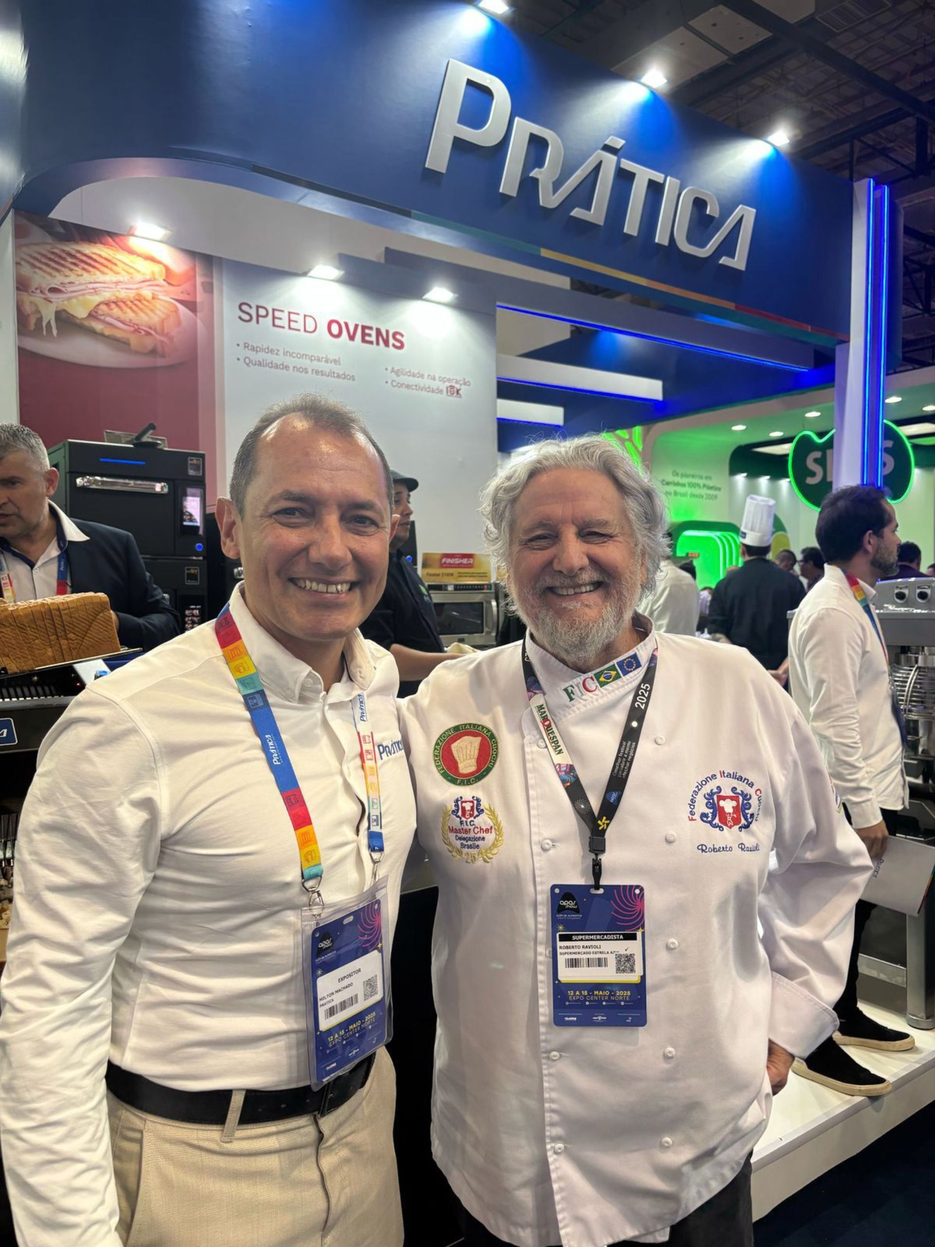 Dois homens estão posando para uma foto em frente a uma placa que diz prática.