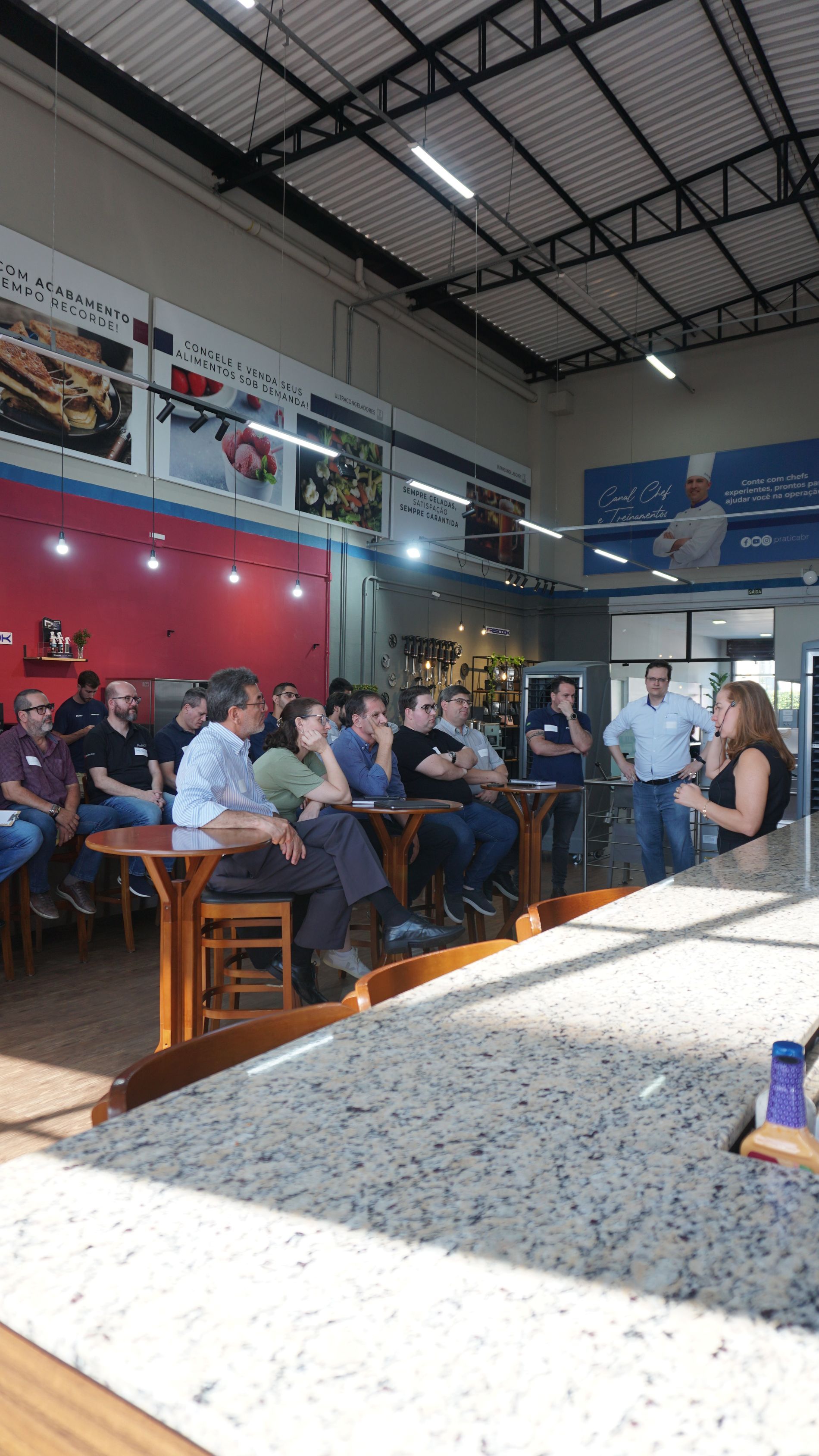 Um grupo de pessoas está sentado em mesas em um restaurante.