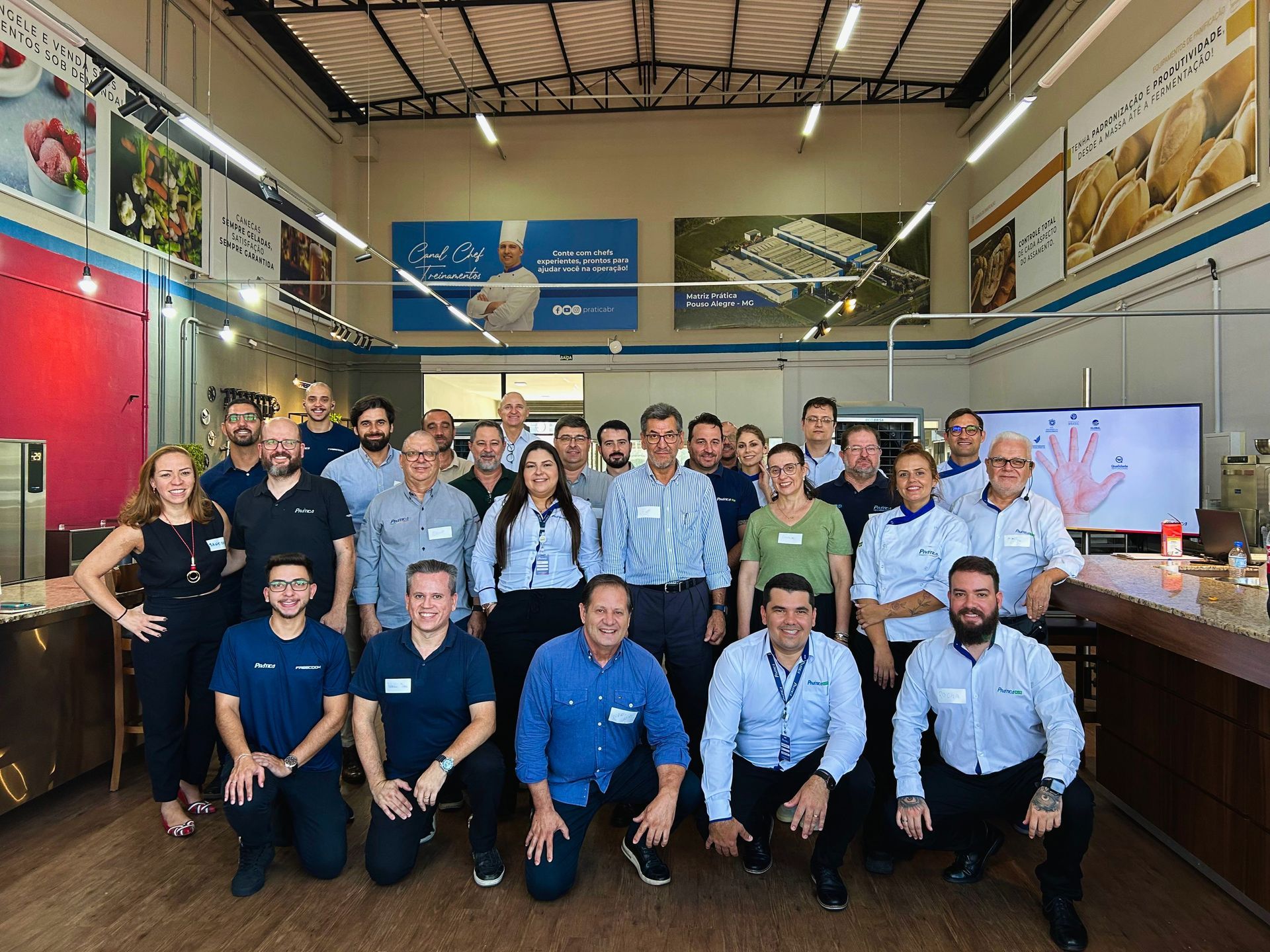 Um grupo de pessoas está posando para uma foto em uma sala.