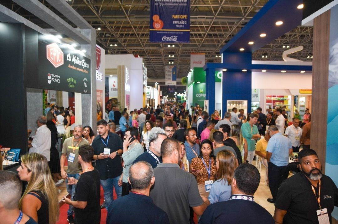 A large group of people are standing in a room at a convention.