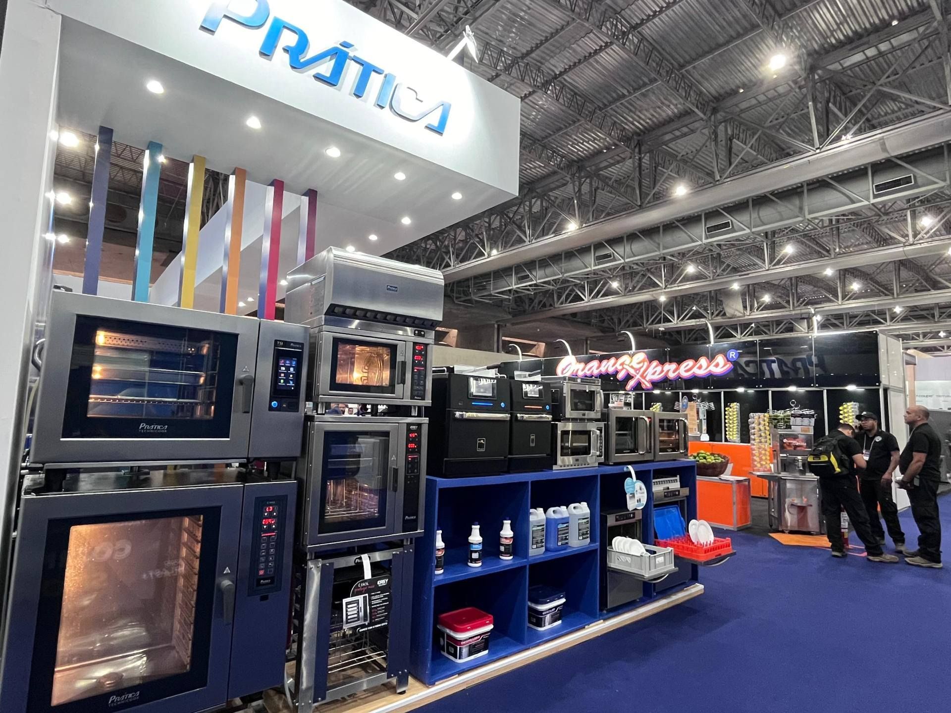 Um grupo de pessoas está em uma sala com muitos aparelhos.