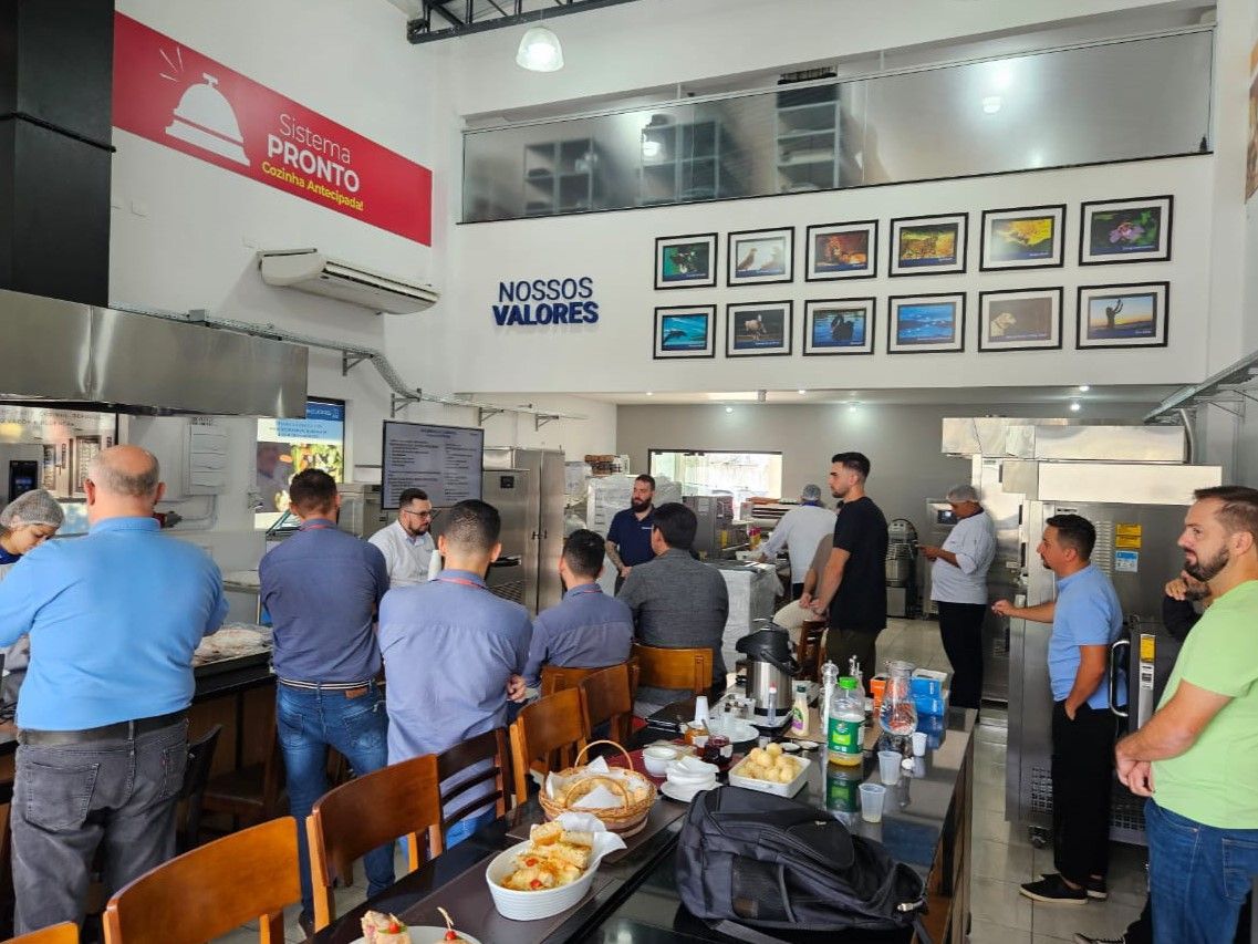 Um grupo de homens está sentado em mesas em um restaurante.