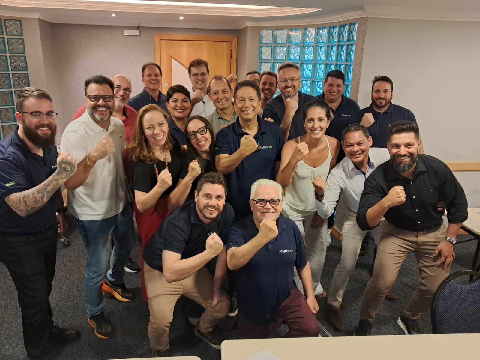 Um grupo de pessoas está posando para uma foto em uma sala.