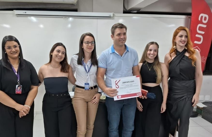 Um grupo de pessoas de pé, uma ao lado da outra, segurando um certificado.