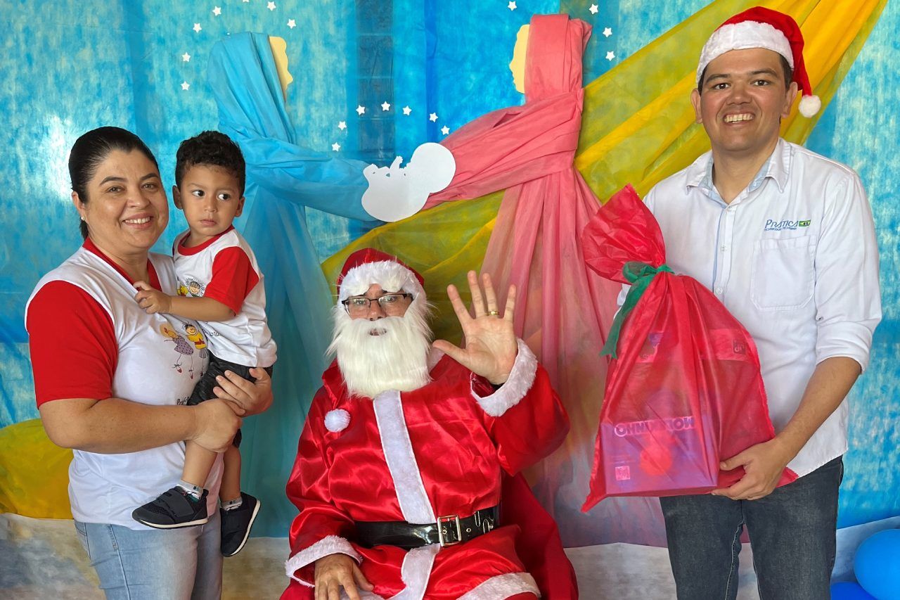 Um grupo de pessoas posando para uma foto com o Papai Noel.
