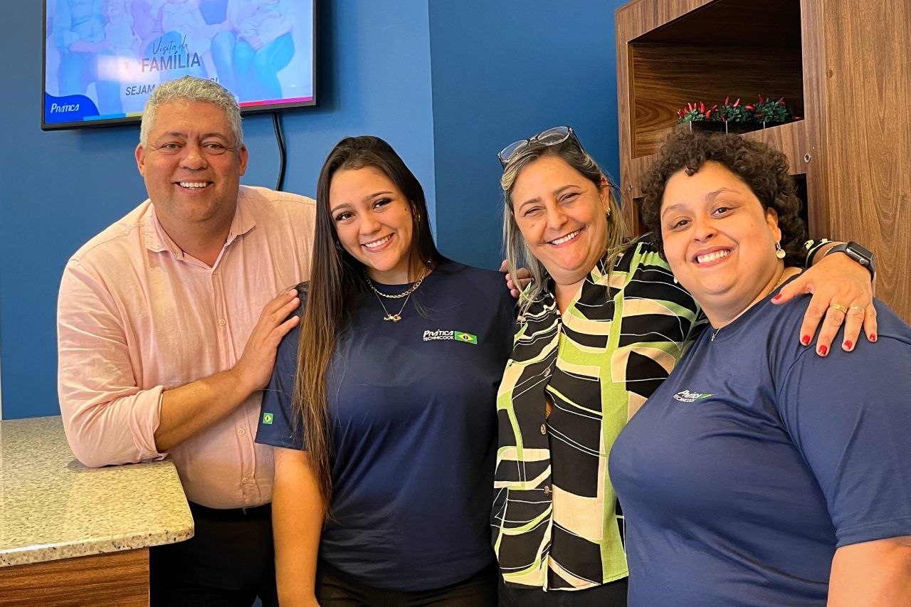 Um grupo de pessoas posa para uma foto em uma sala.