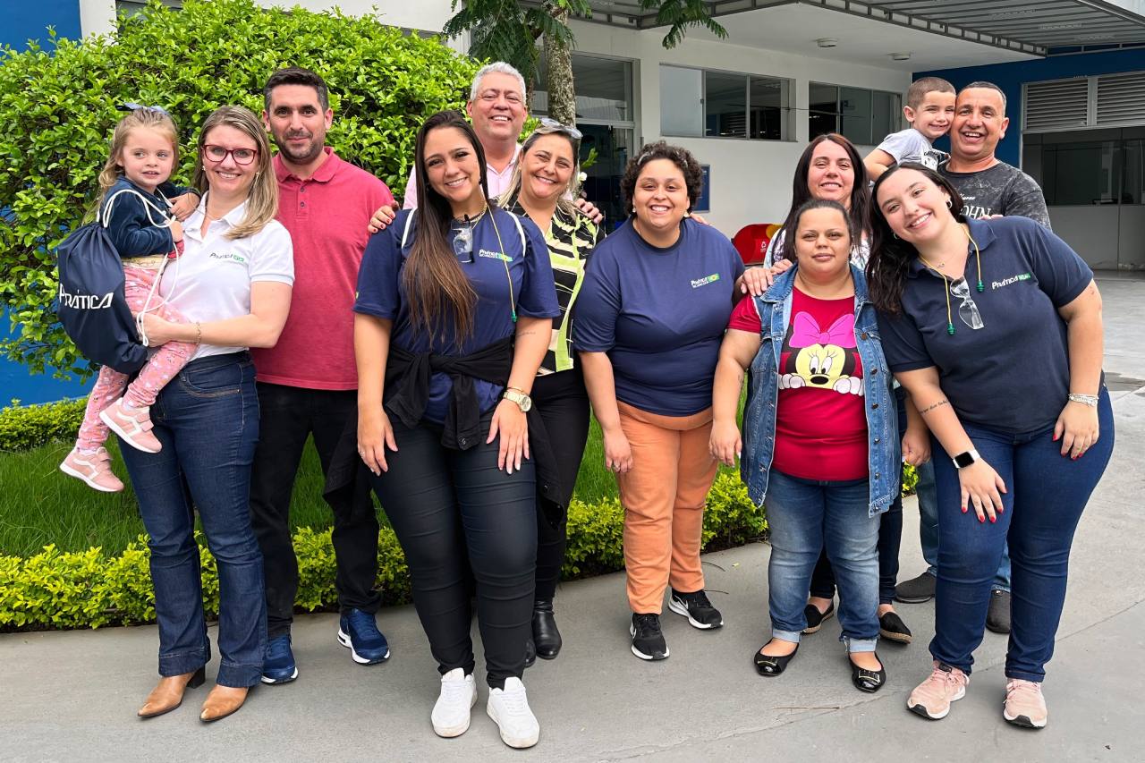 Um grupo de pessoas posa para uma foto em frente a um prédio.