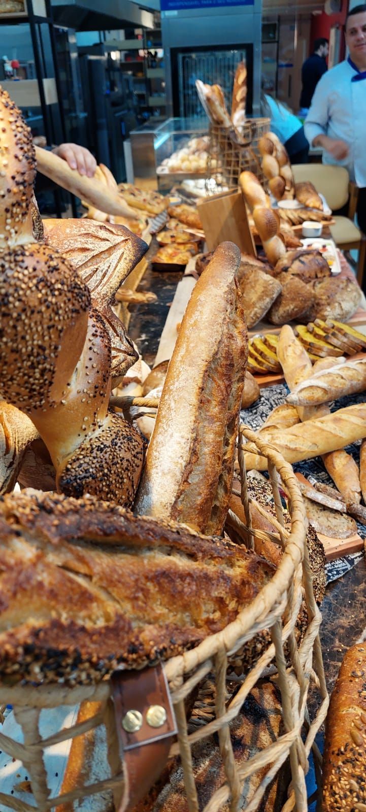 Um monte de pão está sobre uma mesa em uma padaria.