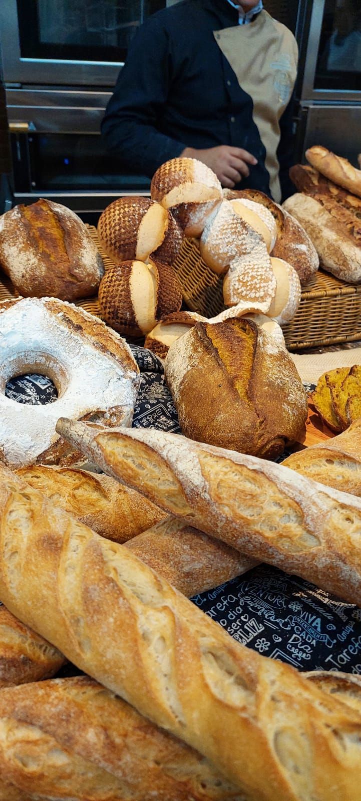 Há muitos tipos diferentes de pão na mesa.