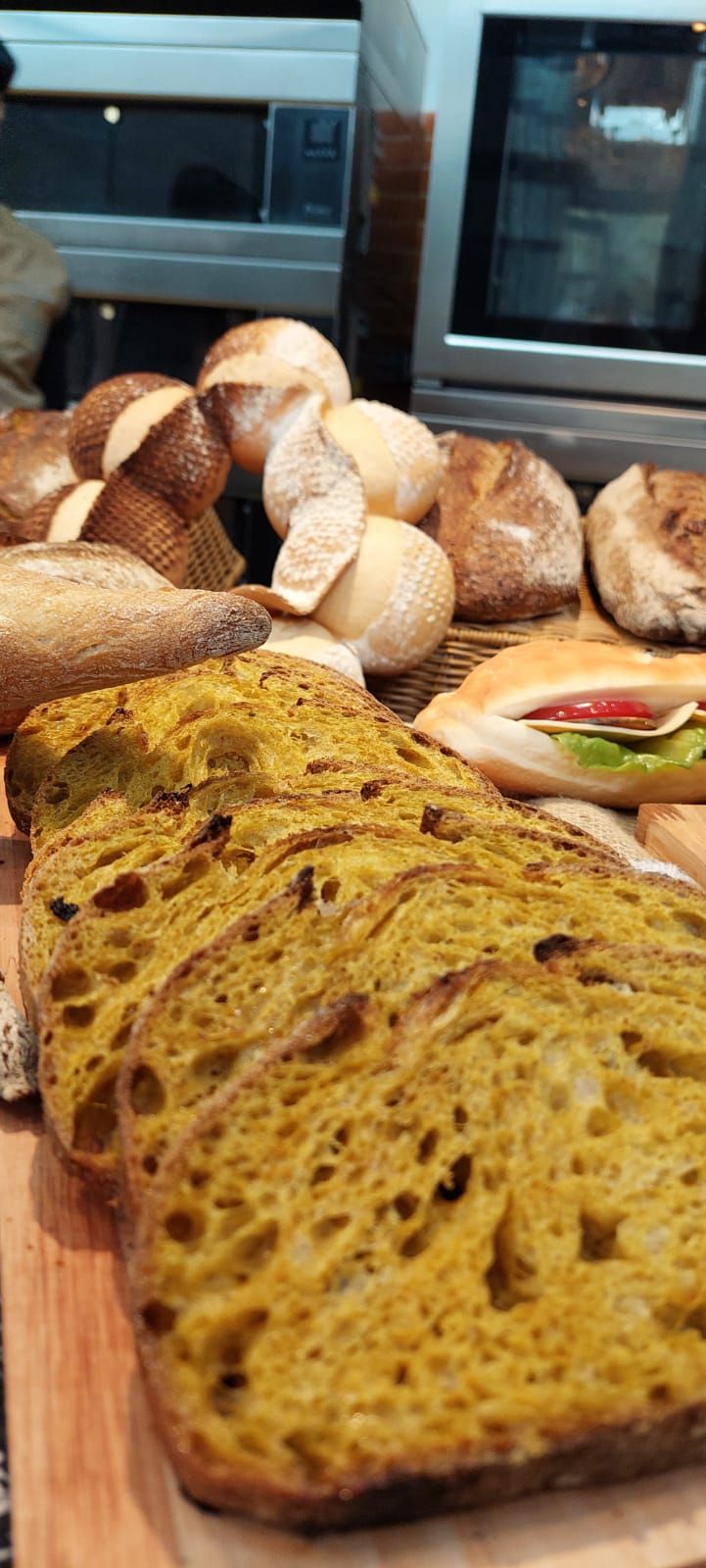 Um pedaço de pão está em cima de uma tábua de corte de madeira.