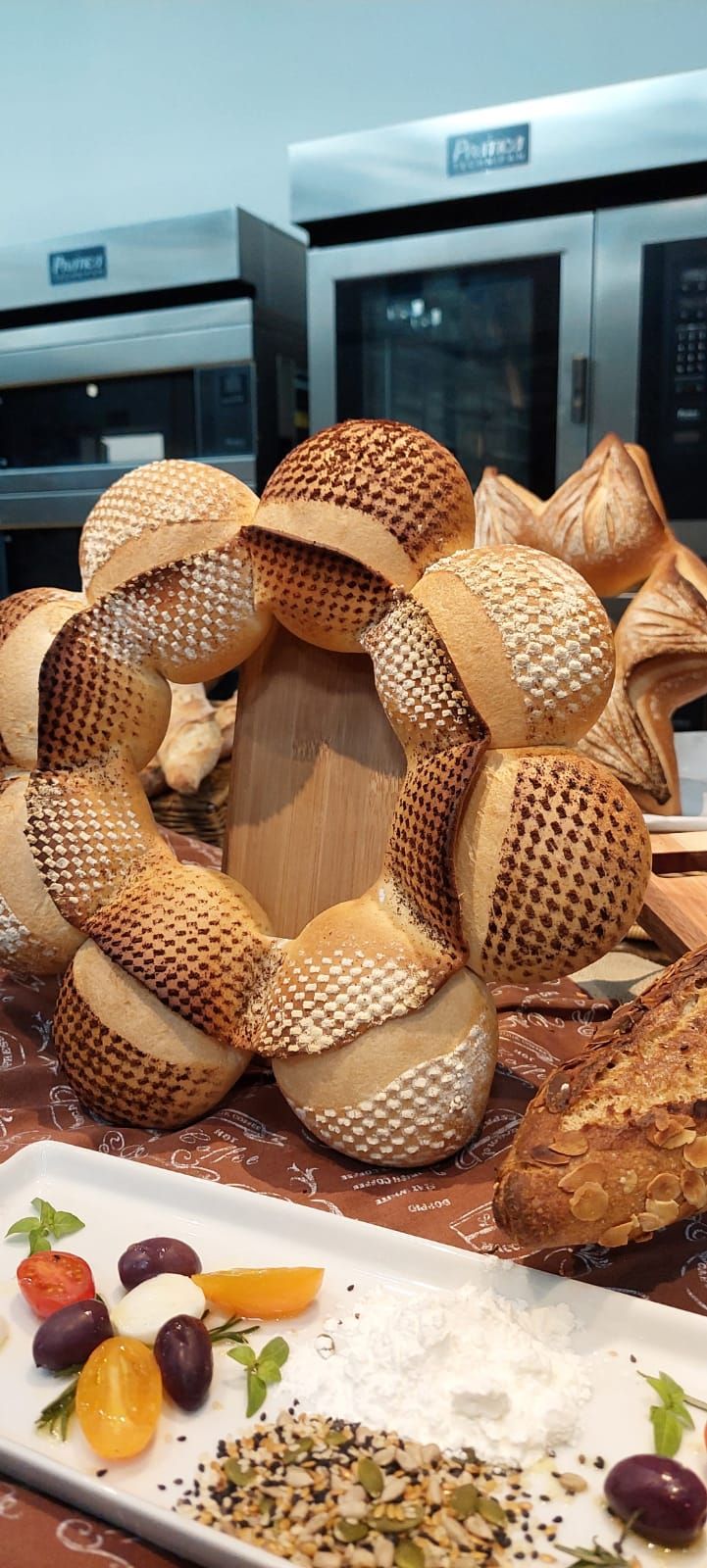 Um monte de pão está sobre uma mesa ao lado de um prato de comida.