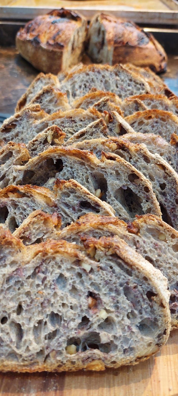 Um pedaço de pão está em cima de uma tábua de corte de madeira.