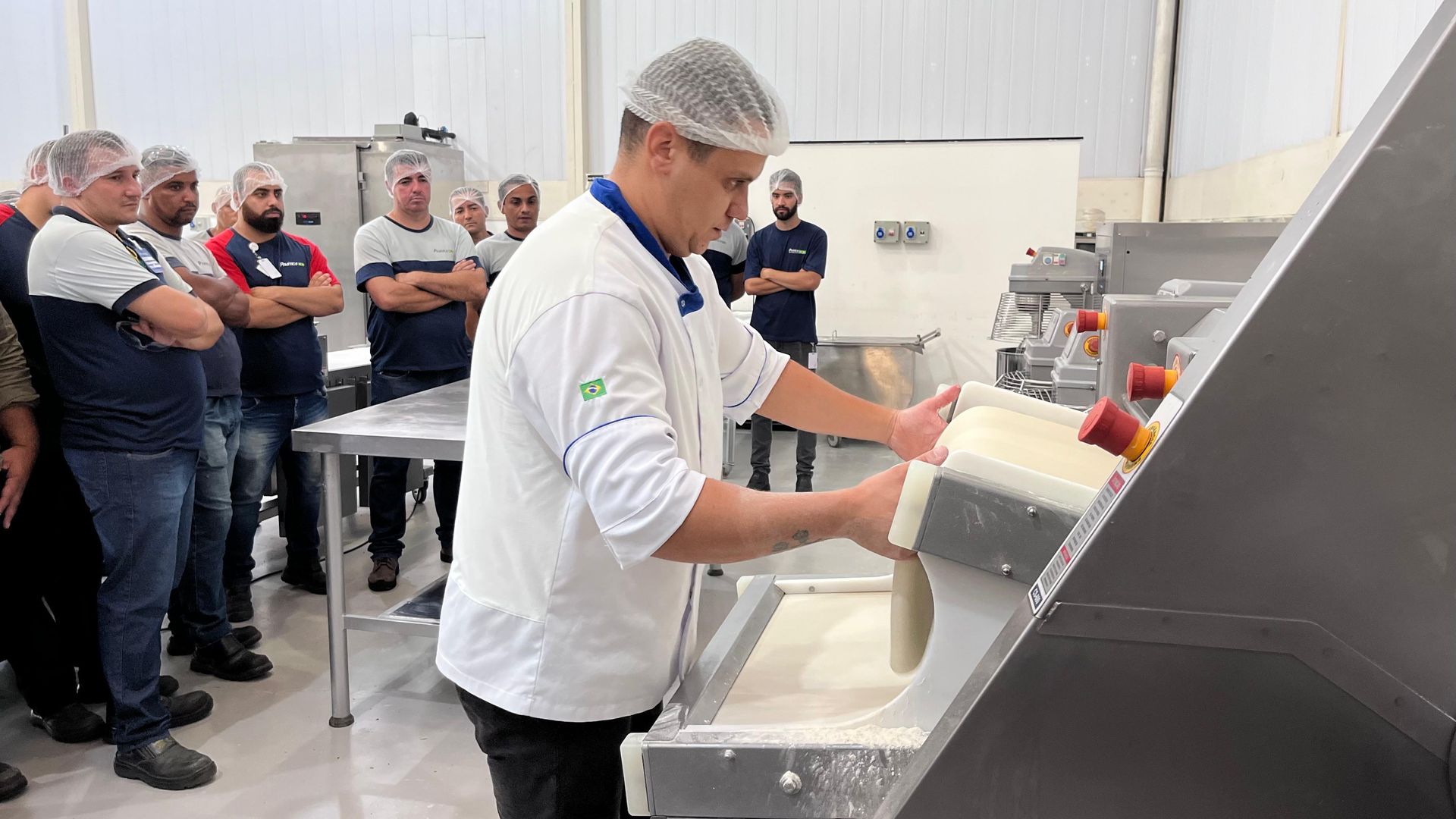 Um homem está parado em frente a uma máquina em uma cozinha.