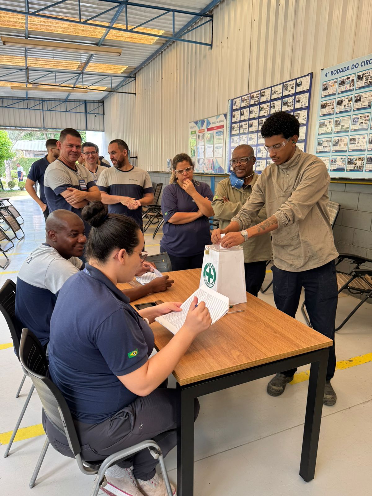 Um grupo de pessoas está sentado à mesa em um armazém.