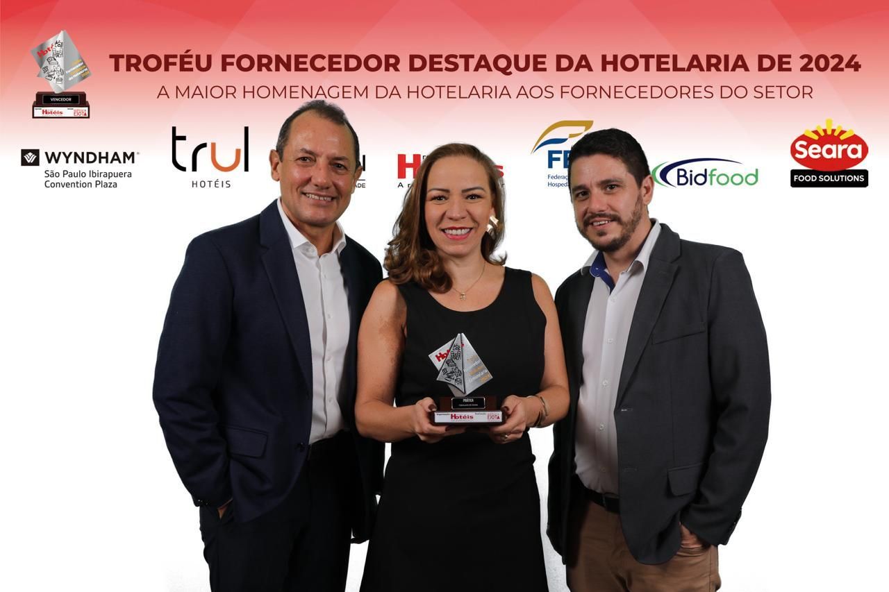 Um grupo de pessoas de pé, uma ao lado da outra, segurando um troféu.