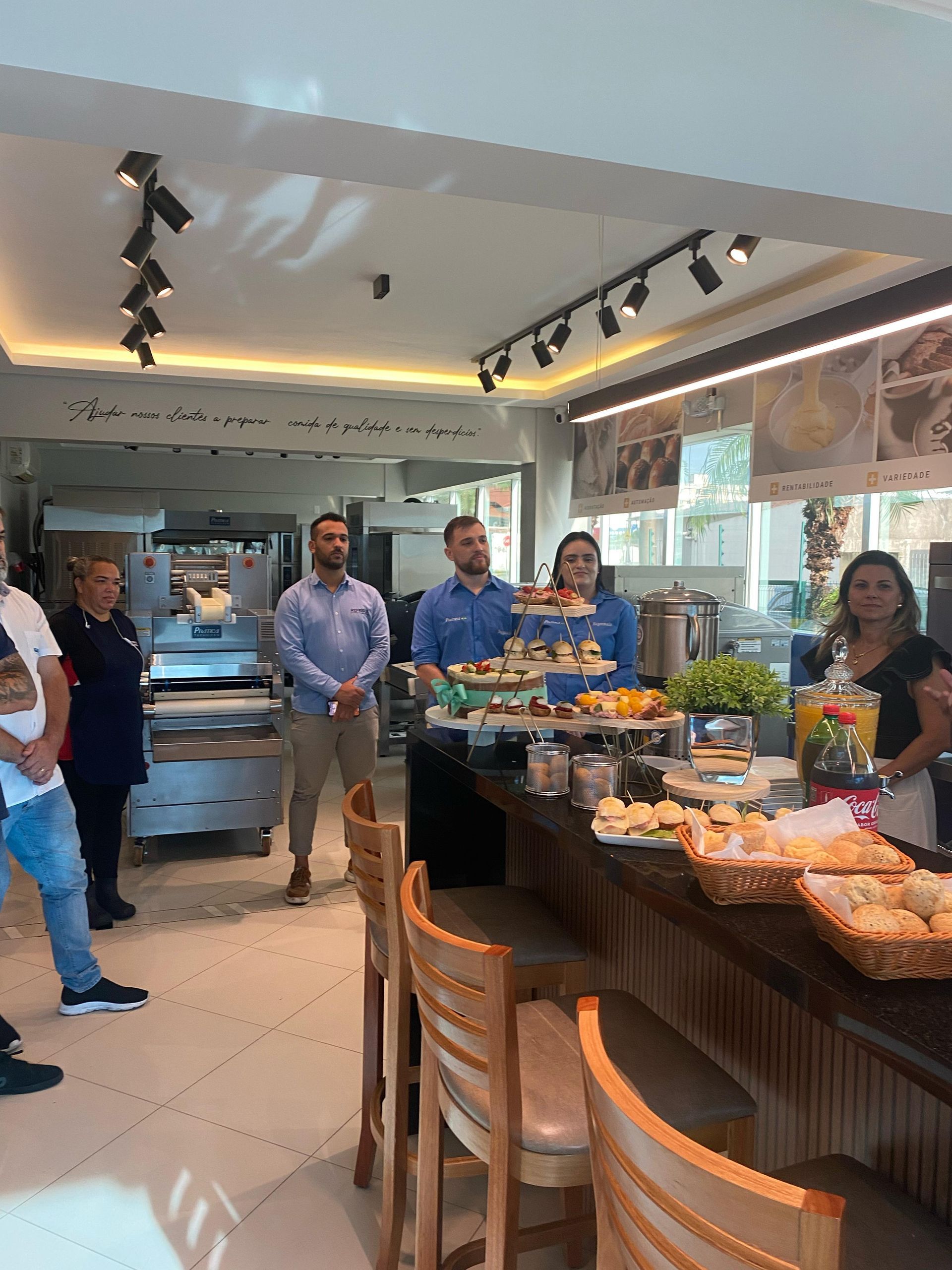 Um grupo de pessoas está em pé ao redor de uma mesa em um restaurante.