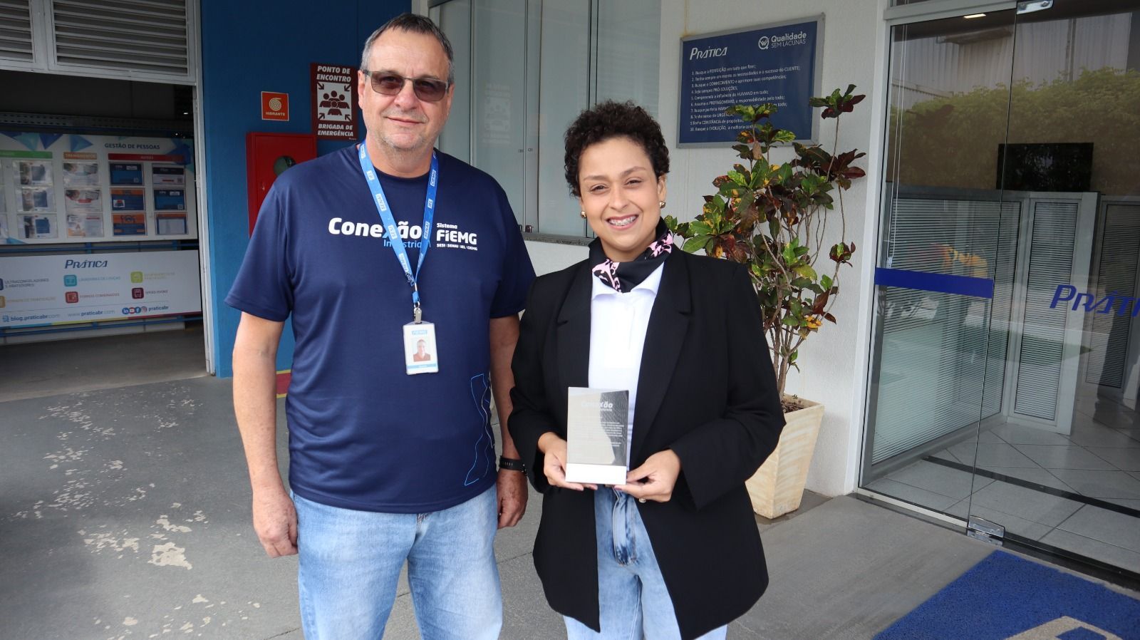 Um homem e uma mulher estão parados um ao lado do outro em frente a um prédio.