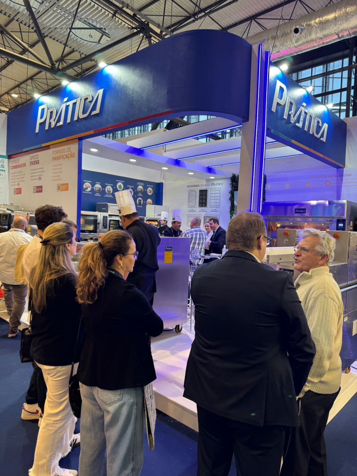 Um grupo de pessoas está em frente a um estande que diz protex