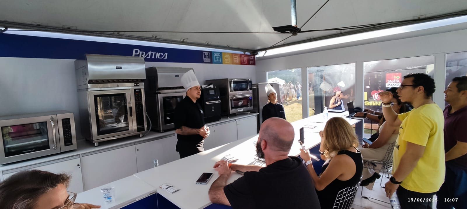 Um grupo de pessoas está sentado à mesa na cozinha.