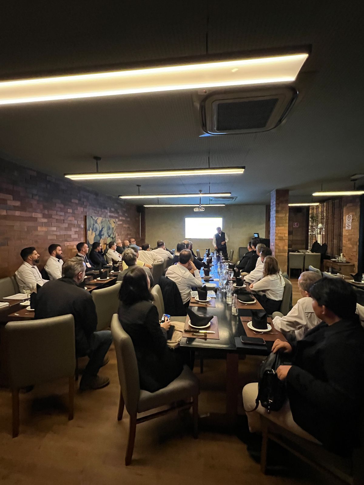 Um grupo de pessoas está sentado em mesas em um restaurante.