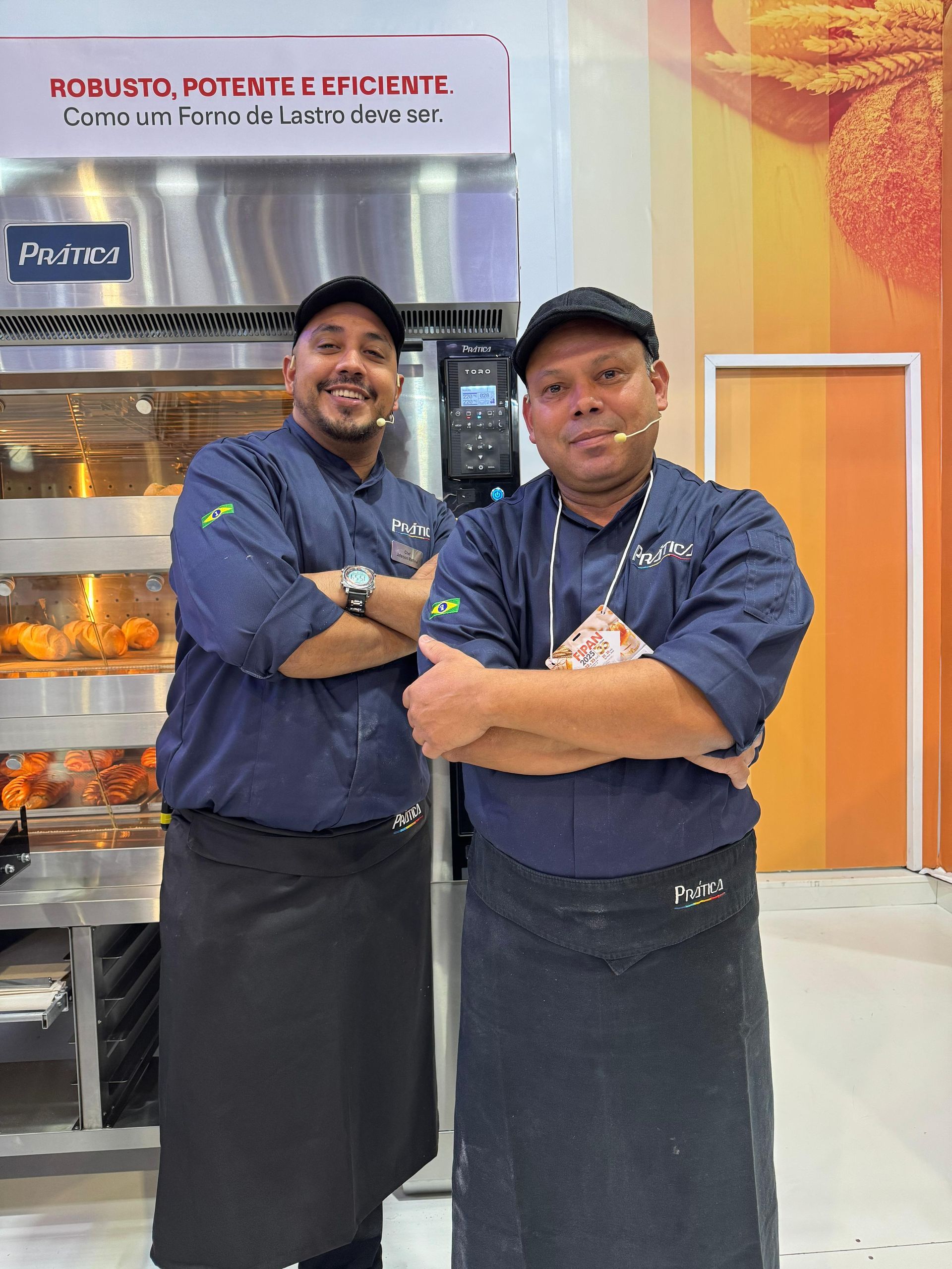 Dois homens estão posando para uma foto em frente a uma vitrine de frango frito.
