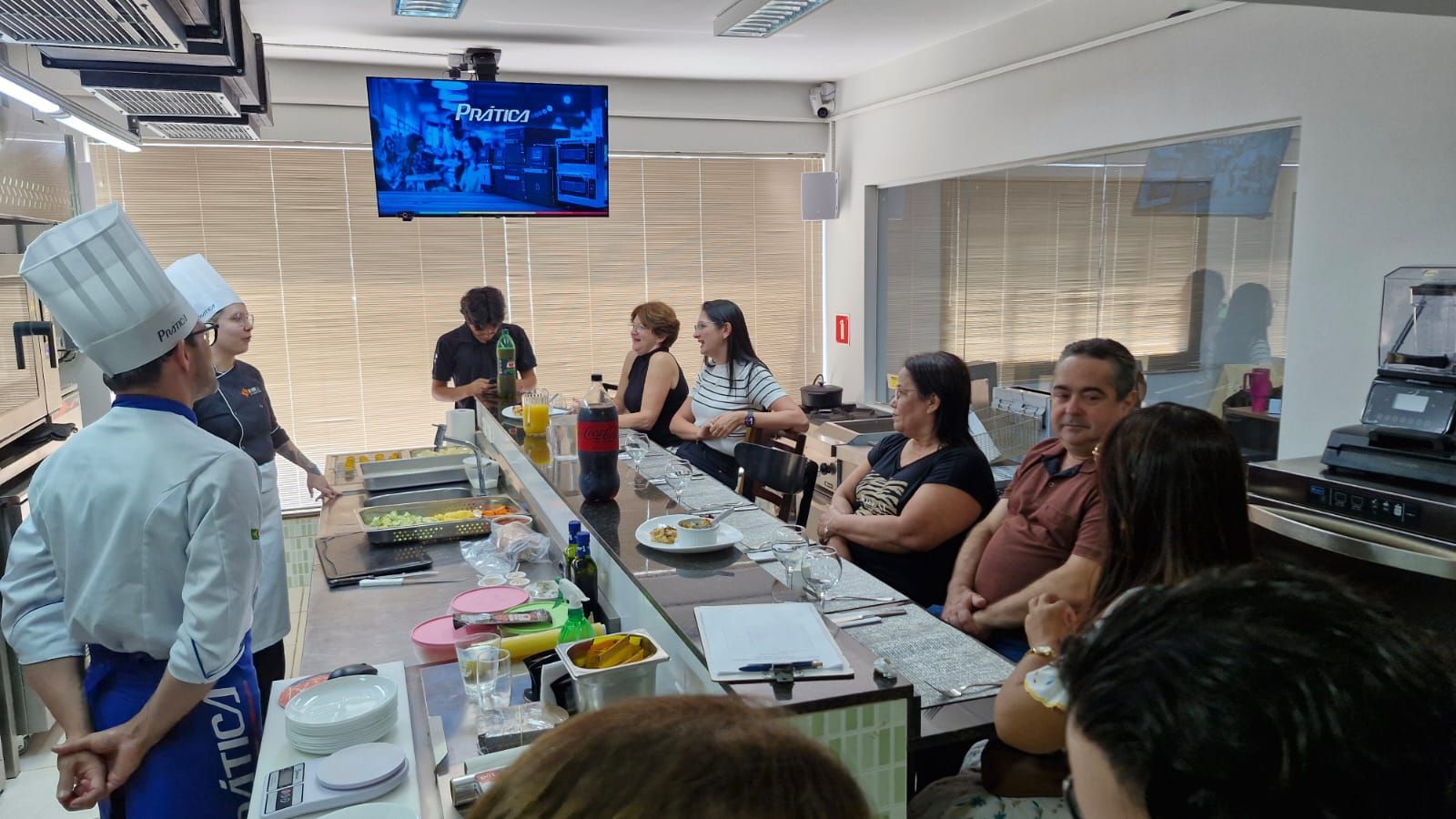 Chef demonstrando como fazer sushi para um grupo de pessoas no balcão de um restaurante.