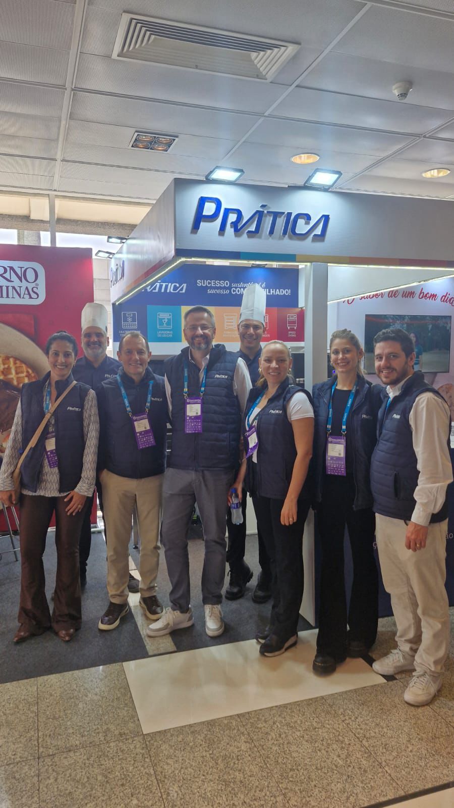 Grupo de pessoas em um estande com o logotipo da