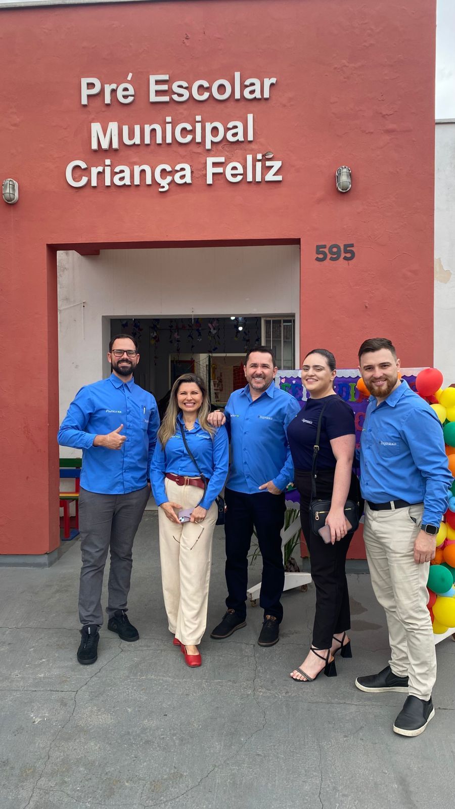 Group of people in blue shirts standing outside 