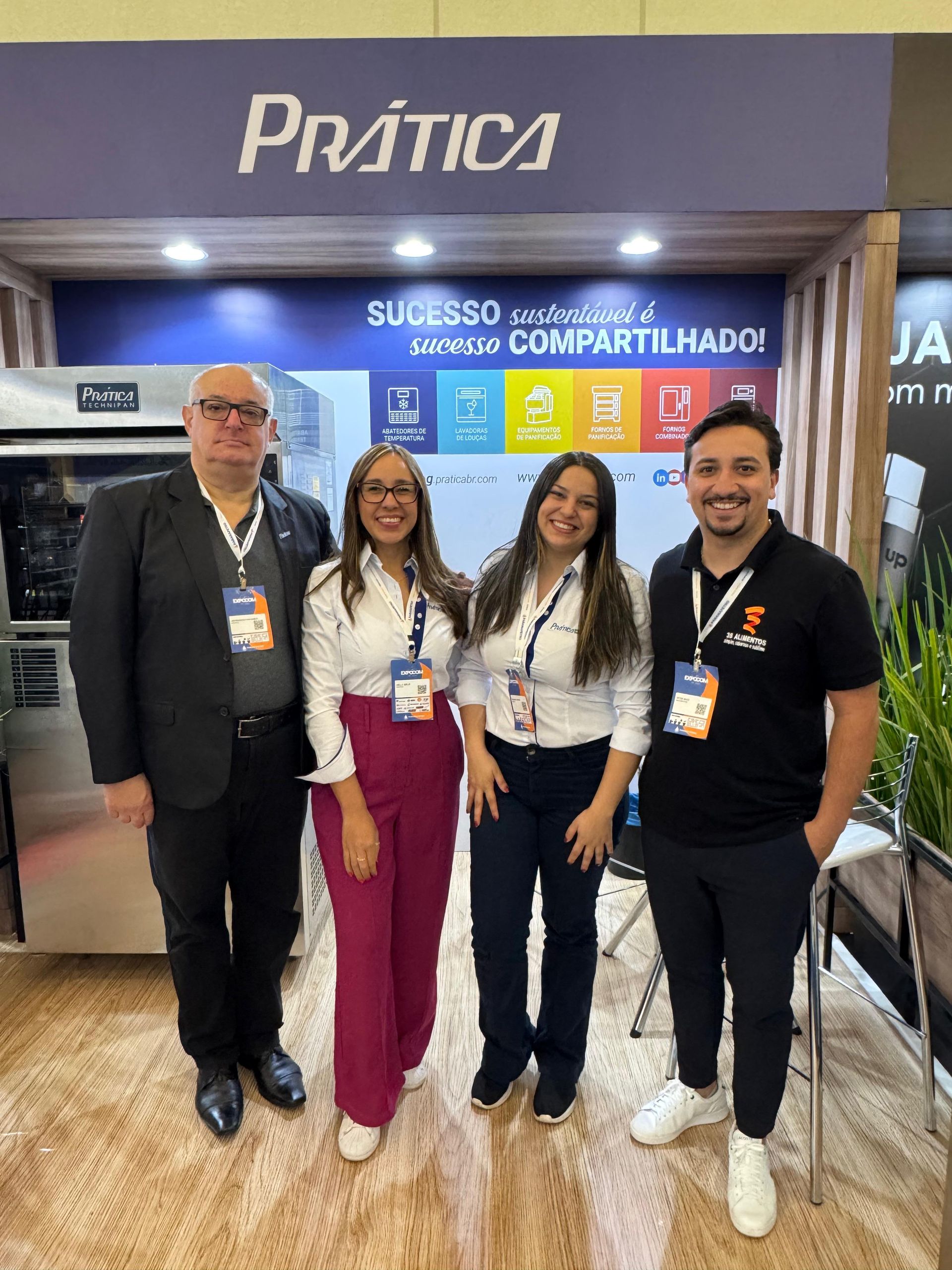 Quatro pessoas estão em frente a uma barraca da 