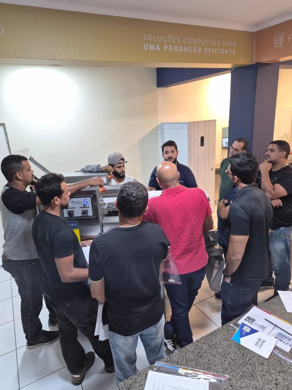 Grupo de homens reunidos em volta de um balcão